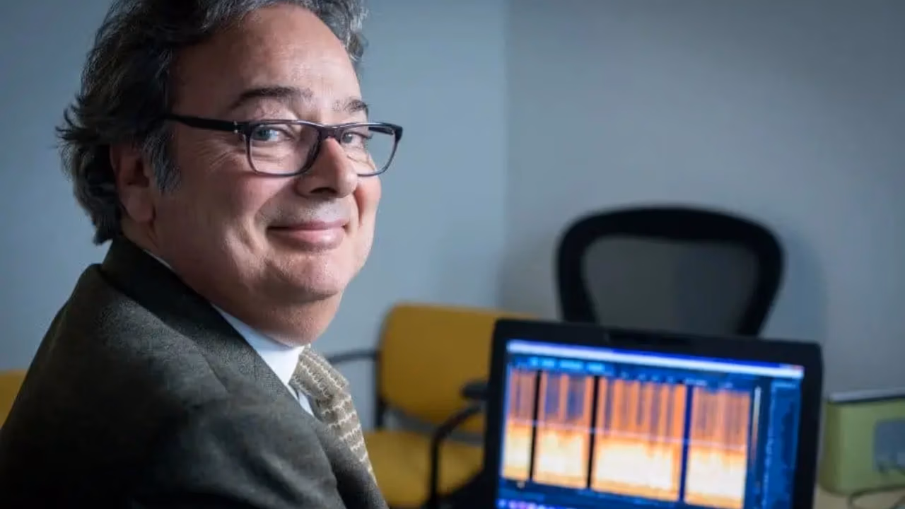 Edward Primeau, lead expert at Primeau Forensics, smiling next to a laptop displaying an orange audio spectrogram. The image highlights his digital audio analysis work, including his forensic audio consulting for high-profile media like the History Channel Flight 93 documentary.